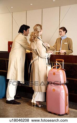Stock Photo - Couple checking in at hotel reception. Fotosearch