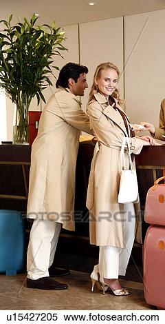 Couple checking in at hotel reception View Large Photo Image Stock Photography - Couple checking in at hotel reception. Fotosearch