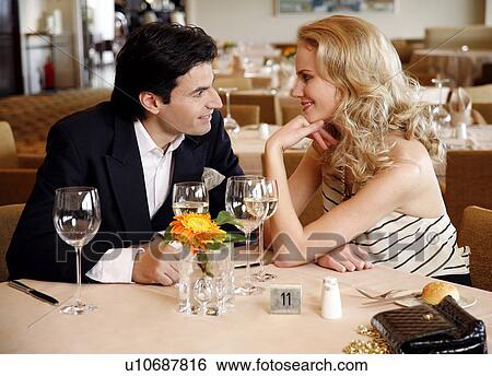Couple having a romantic moment in a restaurant View Large Photo Image Stock Photograph - Couple having a romantic moment in a restaurant. Fotosearch