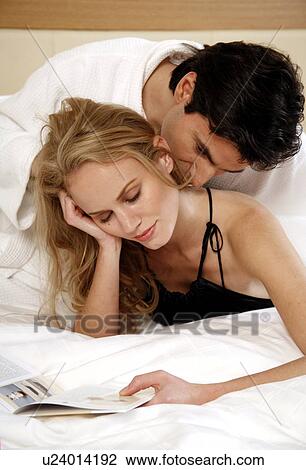 Couple relaxing in bed View Large Photo Image Stock Image - Couple relaxing in bed. Fotosearch