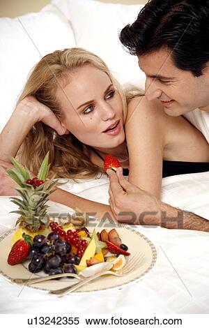 Couple relaxing in bed View Large Photo Image Stock Photography - Couple relaxing in bed. Fotosearch