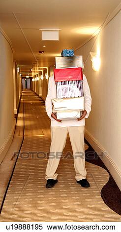 Stock Photography - Hotel bellboy carrying gifts in the corridor. Fotosearch