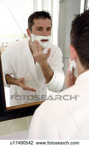Stock Image - Man shaving in front of mirror. Fotosearch