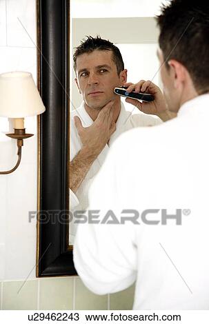 Man shaving in front of mirror View Large Photo Image Stock Image - Man shaving in front of mirror. Fotosearch