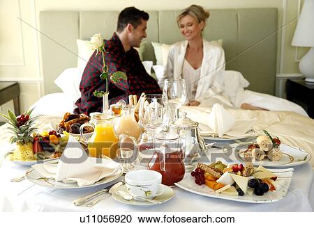 Stock Image - Mature couple having room service breakfast. Fotosearch