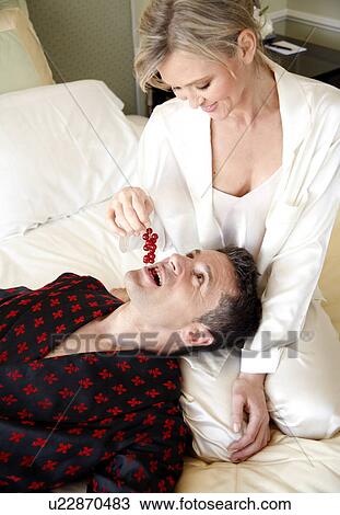 Stock Image - Mature couple having room service breakfast. Fotosearch