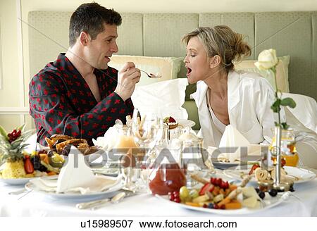 Mature couple having room service breakfast View Large Photo Image Stock Photo - Mature couple having room service breakfast. Fotosearch