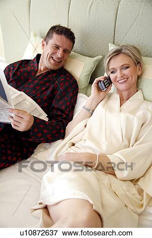 Mature couple relaxing in bed View Large Photo Image Stock Photo - Mature couple relaxing in bed. Fotosearch
