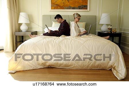 Mature couple working in bed View Large Photo Image Picture - Mature couple working in bed. Fotosearch