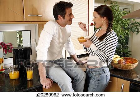 A young couple eating breakfast View Large Photo Image Stock Image - A young couple eating breakfast. Fotosearch