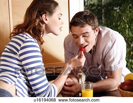 A young couple eating breakfast View Large Photo Image Stock Photo - A young couple eating breakfast. Fotosearch