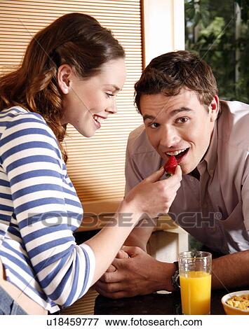 Stock Photo - A young couple eating breakfast. Fotosearch