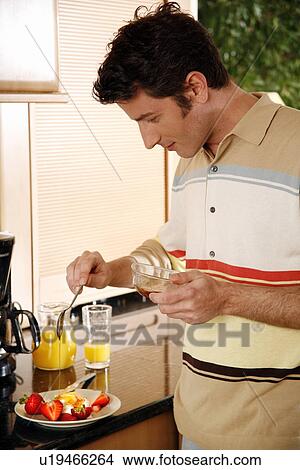 Picture - Man eating his breakfast. Fotosearch
