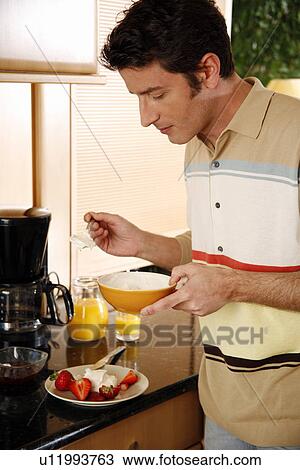Stock Image - Man eating his breakfast. Fotosearch