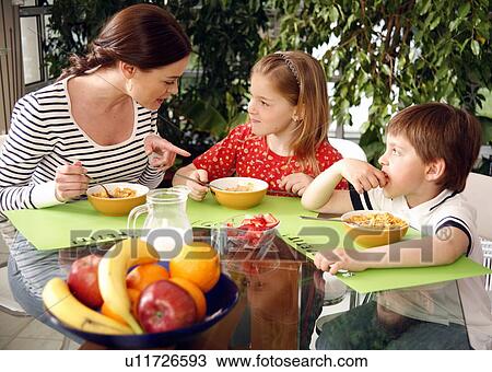 Mother and children eating breakfast View Large Photo Image Stock Image - Mother and children eating breakfast. Fotosearch