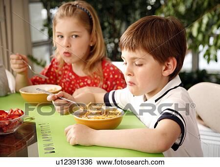 Mother and children eating breakfast View Large Photo Image Stock Photograph - Mother and children eating breakfast. Fotosearch