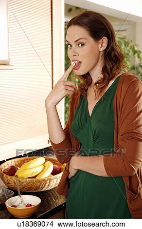 Picture - Woman eating her breakfast. Fotosearch
