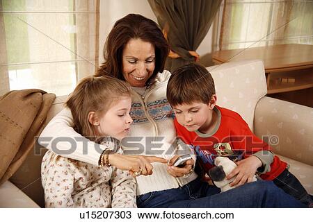 Grandmother relaxing with grandchildren View Large Photo Image Stock Image - Grandmother relaxing with grandchildren. Fotosearch