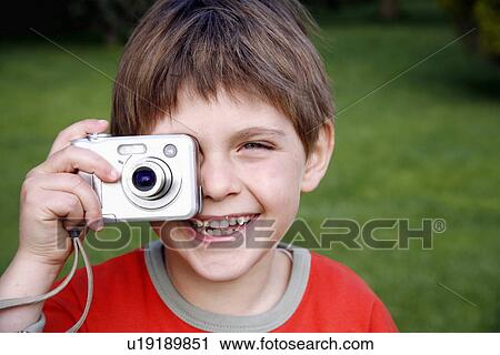 Stock Image - Little boy holding a camera. Fotosearch