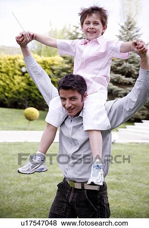 Man carrying a little boy on his shoulders View Large Photo Image Stock Photo - Man carrying a little boy on his shoulders. Fotosearch