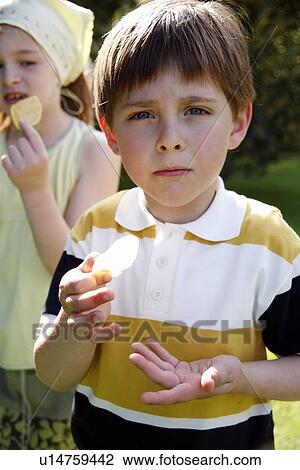 Stock Image - Children eating potato chips. Fotosearch