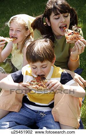Stock Image - Three children eating pizza. Fotosearch