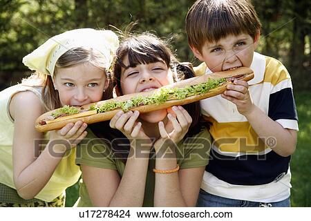 Picture - Three children sharing a large sandwich. Fotosearch