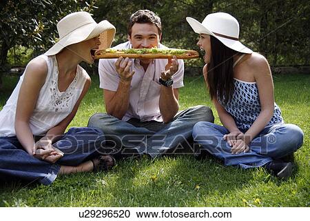 Three friends sharing a big sandwich View Large Photo Image Stock Image - Three friends sharing a big sandwich. Fotosearch