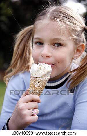 Stock Photo - Young girl eating ice cream . Fotosearch