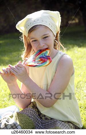 Picture - Young girl licking a lollipop. Fotosearch