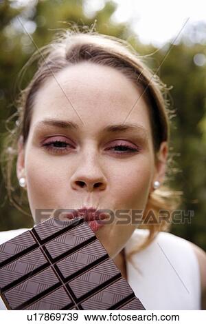 Stock Photo - Young woman eating chocolate. Fotosearch