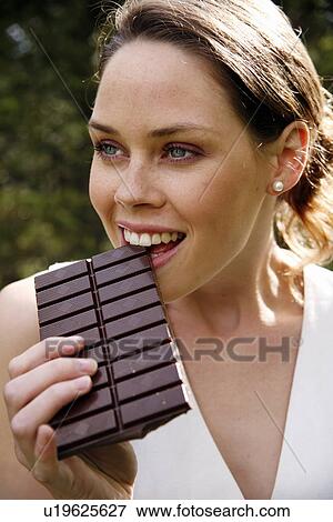 Stock Photo - Young woman eating chocolate. Fotosearch