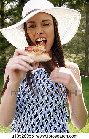 Stock Photography - Young woman eating pizza. Fotosearch