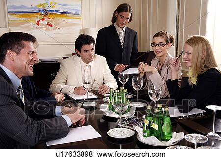 Stock Photo - Business people sitting at a conference table. Fotosearch
