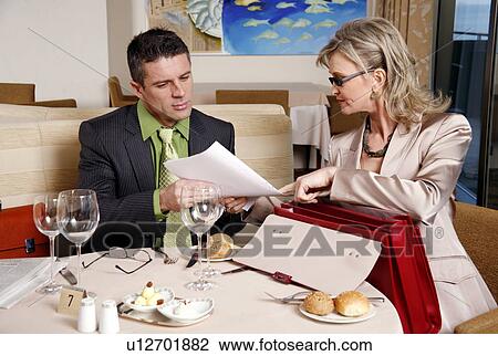 Stock Image - Businessman and businesswoman meeting in a restaurant. Fotosearch