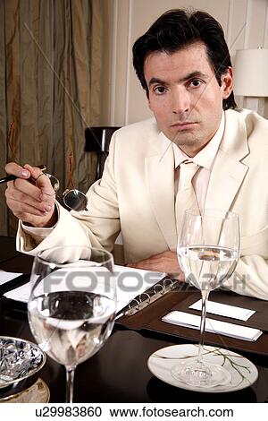 Stock Image - Businessman sitting at a conference table. Fotosearch