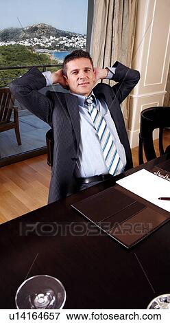 Stock Photo - Businessman sitting at a conference table. Fotosearch
