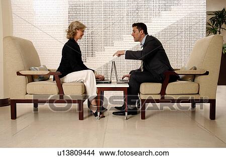 Man and woman sitting in hotel lobby View Large Photo Image Picture - Man and woman sitting in hotel lobby. Fotosearch