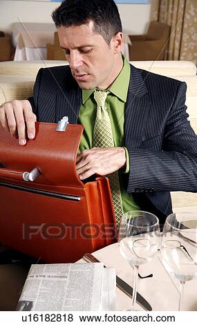 Stock Photo - Man sitting at the table in a restaurant. Fotosearch