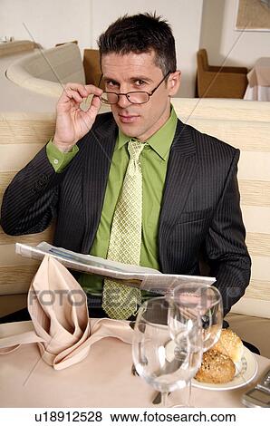 Stock Photo - Man sitting at the table in a restaurant. Fotosearch
