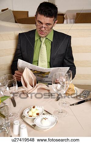 Stock Photo - Man sitting at the table in a restaurant. Fotosearch