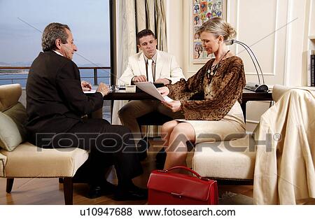 Stock Photo - Three business people working in a hotel room. Fotosearch