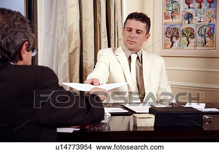 Picture - Two businessmen working in a hotel room. Fotosearch