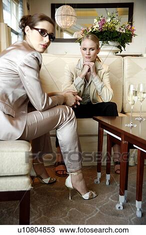 Stock Image - Two girls talking during a business meeting. Fotosearch
