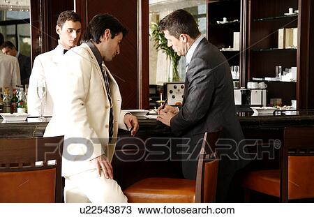 Two men at a bar paying the check View Large Photo Image Stock Image - Two men at a bar paying the check. Fotosearch