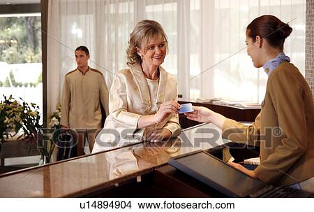 Woman checking in at the hotel reception desk View Large Photo Image Picture - Woman checking in at the hotel reception desk. Fotosearch
