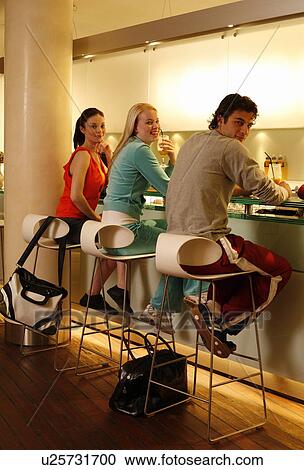 Stock Image - Pilates students at fitness club juice bar. Fotosearch