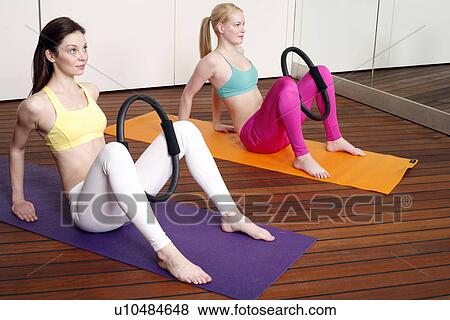 Stock Photo - Two young women performing a pilates exercise. Fotosearch