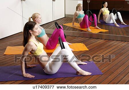 Stock Photo - Two young women performing a pilates exercise. Fotosearch