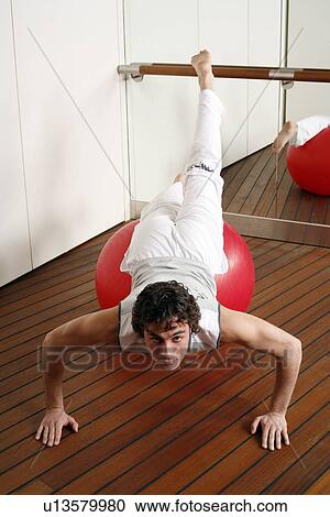 Young man performing a pilates exercise View Large Photo Image Stock Image - Young man performing a pilates exercise. Fotosearch